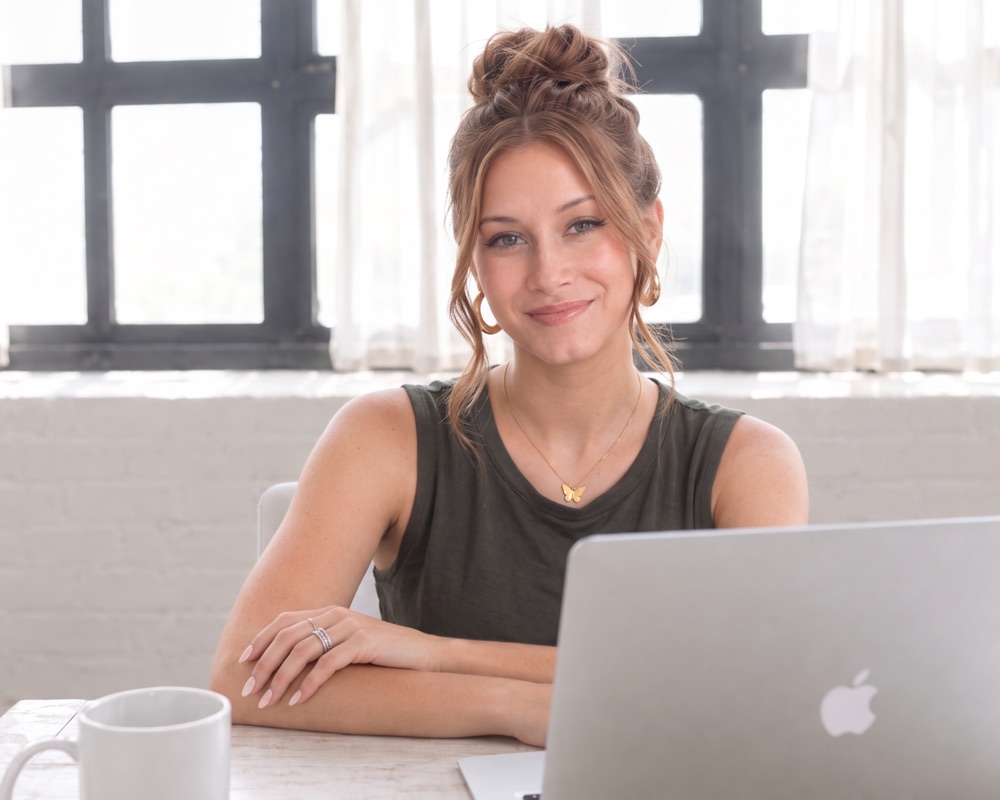 Victoria McCartney, Registered Psychotherapist (Qualifying), at her desk in a bright Toronto office